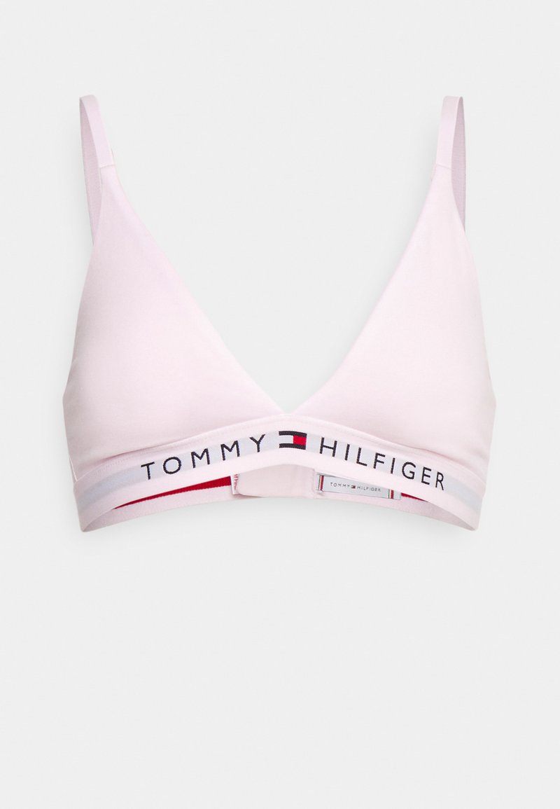 Bralette sans fil rose clair avec une forme triangulaire, arborant une bande élastique de marque en blanc, rouge et bleu autour du bas.