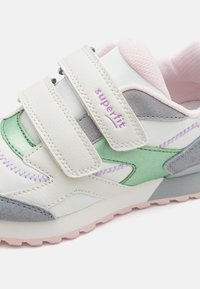 Sneaker i en blandning av vita, grå och gröna syntetiska material. Har två kardborreband, rosa detaljer och texturerade sektioner.