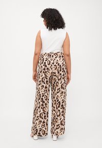 Leopardenmuster weite Hose mit hoher Taille, gefertigt aus weichem Stoff. Verfügt über eine glatte Oberfläche und einen elastischen Bund.