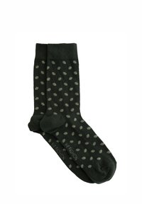 Temnozeleni nogavice z vzorcem pik v svetlejši zeleni. Narejene so iz bombaža, z rebrastimi manšetami in enotno barvo na prstnih in petnih delih.