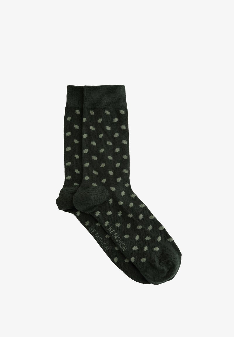 Temnozeleni nogavice z vzorcem pik v svetlejši zeleni. Narejene so iz bombaža, z rebrastimi manšetami in enotno barvo na prstnih in petnih delih.