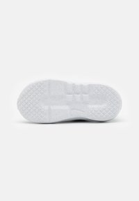 White shoe sole with a textured surface. Features a pattern of squares and lines for grip. Made of a solid material with speckled detail.