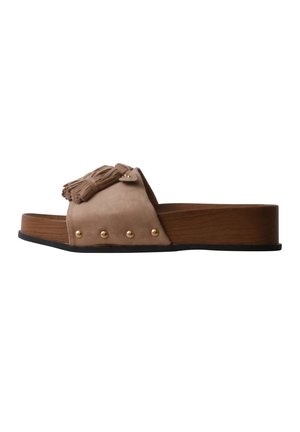 Sandale slide en daim beige avec semelle plateforme en bois, clous dorés sur le côté et pampilles décoratives sur la large bride avant.