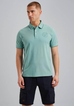 Polo shirt in lichtgroene katoen met drie knopen, korte mouwen en een kraag; voorzien van een bedrukt logo op de borst en contrasterende afwerking.
