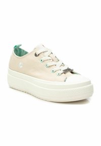 Zapatillas de lona beige con una suela de goma blanca texturizada, que presentan ojales de cordones en azul claro y un pequeño bordado de flores.