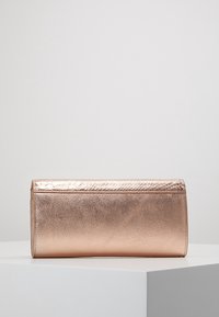 Rosaguld clutchväska med en slät metallfinish, med ett texturerat ormsskinnsmönster på övre kanten och en elegant rektangulär form.