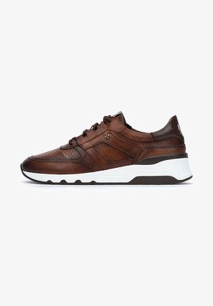 Zapatilla de cuero marrón con textura perforada, suela de goma blanca y un sutil logotipo en el lateral. Presenta un diseño con cordones y un collar acolchado.