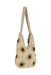 Virkatusta laukusta, jonka rungon väri on beige ja jossa on keltaisia ja ruskeita auringonkukkamotiiveja. Pehmeä kantohihna, jossa on teksturoidu viimeistely.