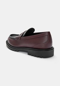 Bordeaux læder loafers med en tekstureret overdel, gummisål og detaljeret syning. Rund tå og lavprofil design.