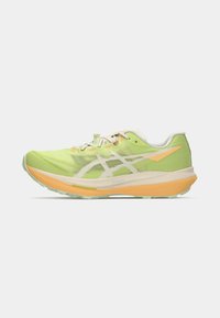 Running shoe with a lightweight green upper, orange accents, textured material, and a thick sole for cushioning. Laces for secure fit.