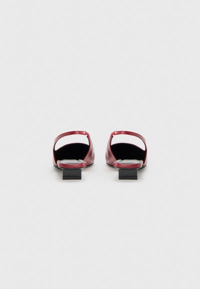 Κόκκινα δερμάτινα παπούτσια με ανοιχτή πλάτη και μικρό μαύρο τακούνι σε σχήμα τετραγώνου, με υφή στο πέλμα και μινιμαλιστικό σχέδιο.