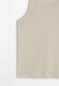 Beige tanktop met een ronde hals, geribbelde textuur en mouwloos ontwerp. Gemaakt van een zachte, lichtgewicht stof.