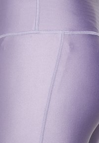 Lilac athletic leggings made of stretchy fabric, featuring smooth texture and flat seams for comfort. No visible patterns or hardware.