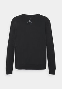 Černá mikina s dlouhými rukávy, kulatým výstřihem a šedým logem Jumpman na zadní straně. Tkanina má hladkou texturu a uvolněný střih.