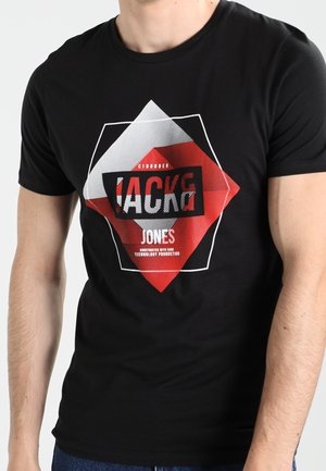 Mand iført sort tætsiddende T-shirt med geometrisk rødt, hvidt og sort design og teksten "Jack & Jones" foran.