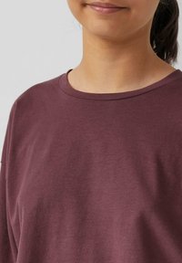 Bordeaux katoenen T-shirt met een ronde hals, korte mouwen en een gladde textuur. Geen zichtbare patronen of hardware-details.