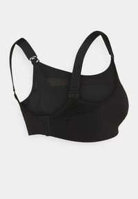 Svart sports-bh med justerbare stropper, laget av et stretchy stoff, med nettingpaneler for pusteevne og en myk, sømløs design.
