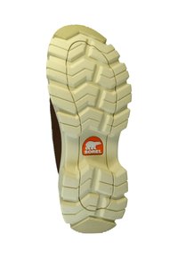 Suola di stivali Sorel con una base in gomma testurizzata color crema, caratterizzata da un motivo a spina di pesce e un logo arancione circolare centrato sul tallone.