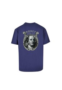 Violets kokvilnas T-krekls ar grafisku attēlu, kurā redzams vīrieša seja, kā arī uzraksts "NAUDA NIKAD NEMALDINA" un dekoratīvi elementi.