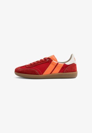 Baskets rouges avec des rayures orange, semelle en caoutchouc marron, patch blanc au talon et lacets rouges, vues de côté sur fond blanc.