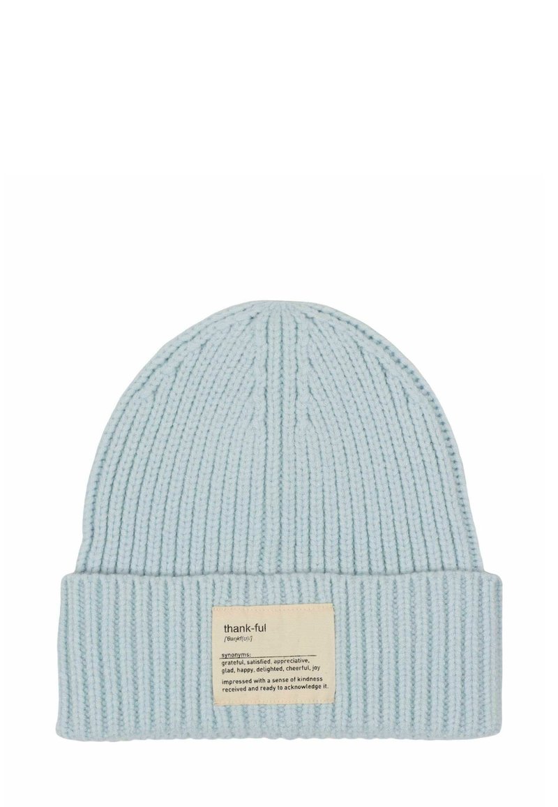 Light blue knitted beanie with ribbed texture and a folded cuff. Features a rectangular fabric label with "thank-ful" and definition.