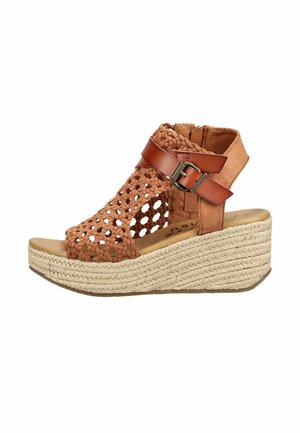 Brązowy pleciony sandał na koturnie z paskiem wokół kostki, zapięciem na klamrę i podeszwą na platformie z plecionej juty.