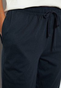 Himmelblaue Baumwollhose mit elastischem Bund und Kordelzug. Mit seitlichen Taschen und einer glatten, leichten Textur.