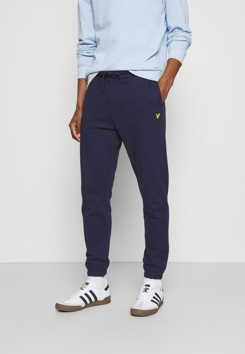 Navy blaue Sweatpants aus Baumwollmischung mit verstellbarem Kordelzugbund und kleinem gelben Logodetail am linken Oberschenkel.