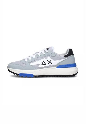 Sneaker in tessuto grigio con accenti bianchi, dotate di un distintivo logo triangolare, una suola blu e una suola nera testurizzata.