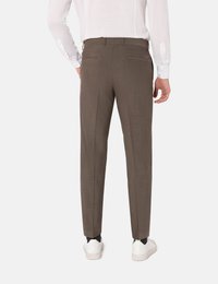Bruine op maat gemaakte broek met een gestructureerde afwerking, twee achterzakken en slim fit, gecombineerd met witte sneakers. Effen witte blouse met lange mouwen zichtbaar.