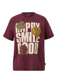 Dieprode T-shirt met vetgedrukte witte tekst "HAPPY SMILE GOOD" en drie smeltende smiley gezichten in olijfgroen, mosterdgeel en dieprood.