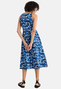 Blue floral dress with a fitted bodice and flared skirt. Features a bright blue background with white and dark blue floral patterns.