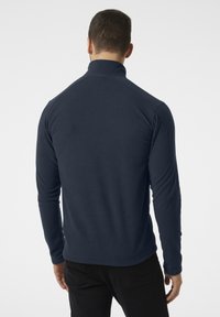 Sudadera de forro polar azul marino con cuello alto, mangas largas y textura suave. Presenta un dobladillo recto y una silueta ajustada.