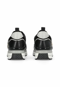 Baskets noires et grises avec une tige en tissu texturé, des accents en cuir élégants, une languette de maintien et une semelle en caoutchouc robuste à motif en zigzag.