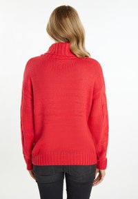 Rode gebreide trui met een hoge kraag, geribbelde manchetten en een losse pasvorm. Gestructureerd patroon op de mouwen en een effen kleur overal.