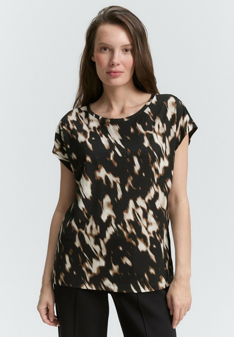 Krátký rukáv blouse v černé, hnědé a krémové abstraktní vzoru. Hladká tkanina s uvolněným střihem a kulatým výstřihem.