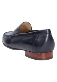 Marineblauwe leren loafer met een lichtgewicht ontwerp, ronde neus en gestikte details. Heeft een lage houten hak en een gladde binnenvoering.