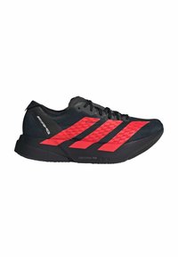 Sort og rød sportsko med en let overdel, fremtrædende røde diagonale striber, tekstureret stof og gummisål med "LIGHTSTRIKE PRO" branding.