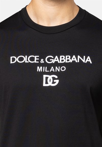 Zwarte katoenen T-shirt met korte mouwen, voorzien van witte geborduurde tekst "DOLCE & GABBANA", "MILANO" en het "DG"-logo op de borst.