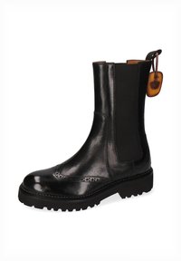 Botín Chelsea de cuero negro con paneles laterales elásticos, detalle de brogue en la puntera y suela de goma resistente. Presenta una etiqueta colgante.