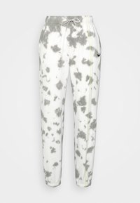 Vita och grå batikmönstrade joggerbyxor med elastisk midja, snöre, cuffs vid anklarna, sidofickor och en liten svart Nike-swoosh på högra sidan.