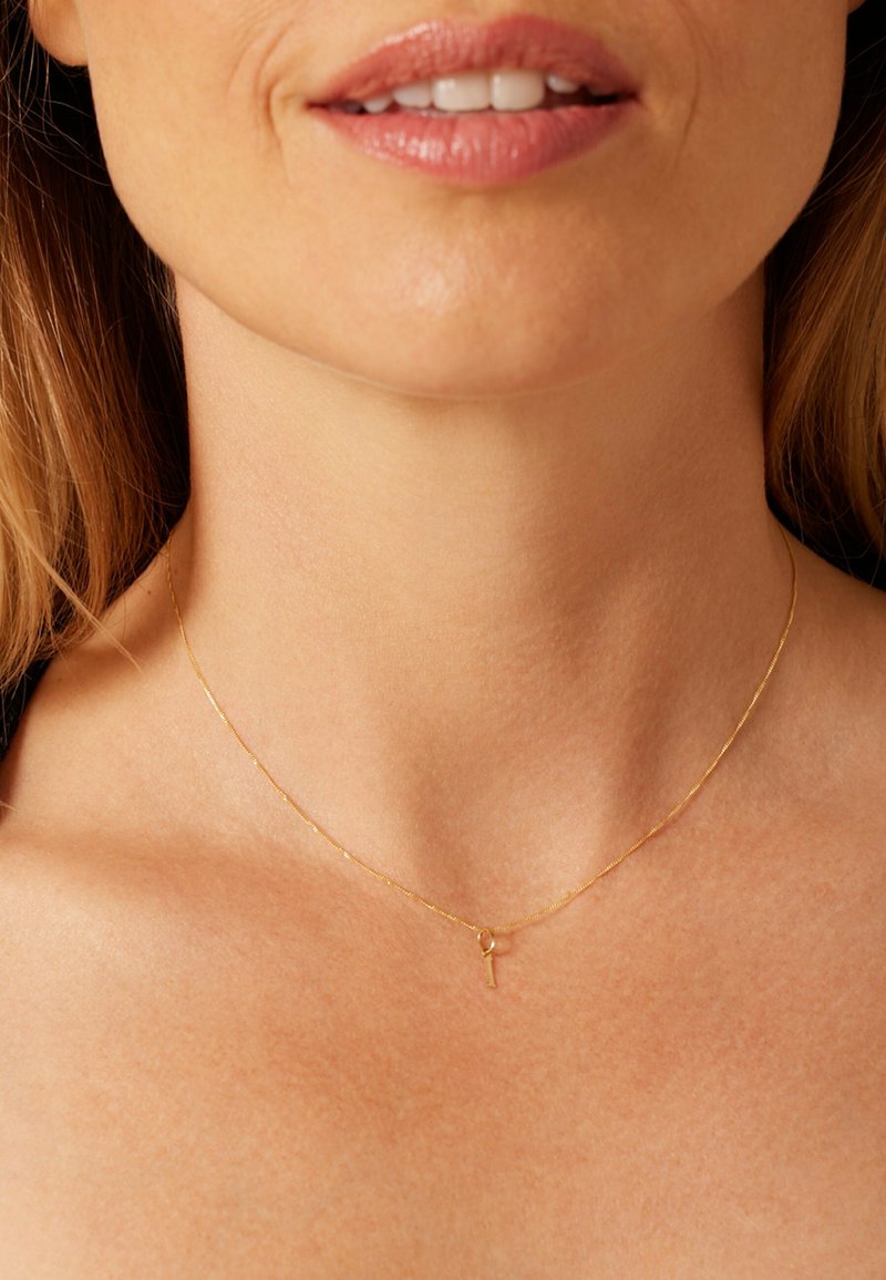 Gold chain necklace featuring a delicate key pendant, with a smooth, refined texture and minimalistic design.