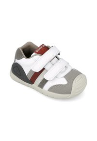 Zapatillas infantiles en blanco y gris con dos tiras de Velcro, suela de goma y detalles en rojo y gris. Presenta acentos de ante.