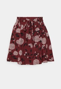 Jupe florale bordeaux avec un design plissé, ornée de fleurs blanches et de feuilles noires, complétée par un lien en tissu assorti à la taille.