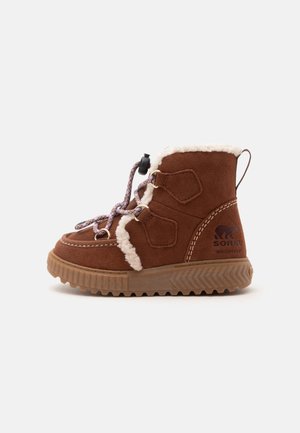 Botte d’hiver imperméable en daim marron avec doublure en polaire blanche, lacets à motifs avec bloque-lacets, et semelle en caoutchouc antidérapante.