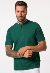 Zelené polo tričko s límečkem, čtyřbuttonsým zapínáním a kontrastním bílým pruhovaným lemem. Měkká tkanina a krátké rukávy.