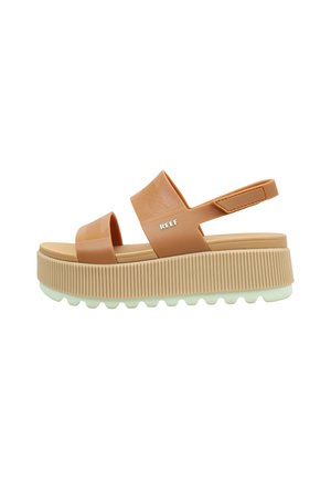 Sandalia de plataforma color tostado con dos tiras anchas, una correa trasera con Velcro, suela gruesa con estrías y logotipo "REEF" en la tira superior.