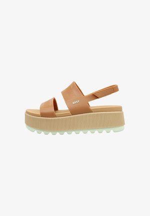Sandale à plateforme marron clair avec deux larges brides, une bride arrière avec velcro, semelle épaisse rainurée et logo "REEF" sur la bride supérieure.