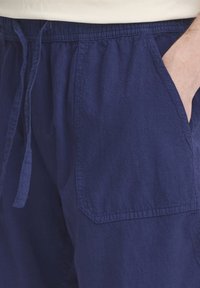 Marineblå bomullsshorts med snor i livet, elastisk midje, sidelommer og teksturert stoff, med pent sydd søm.