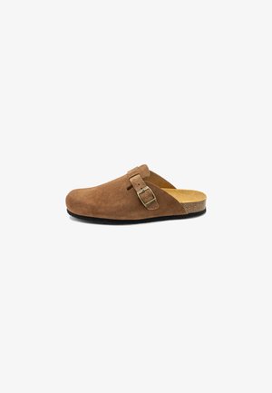 Zoccolo in suede marrone con punta arrotondata, tracolla regolabile singola con fibbia e soletta in sughero, dotato di suola piatta in gomma nera.
